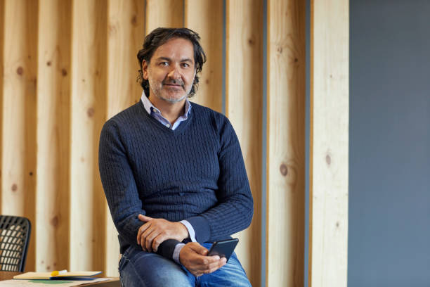 Portrait of confident mature businessman in office. Male entrepreneur is wearing smart casual. He is at coworking space.